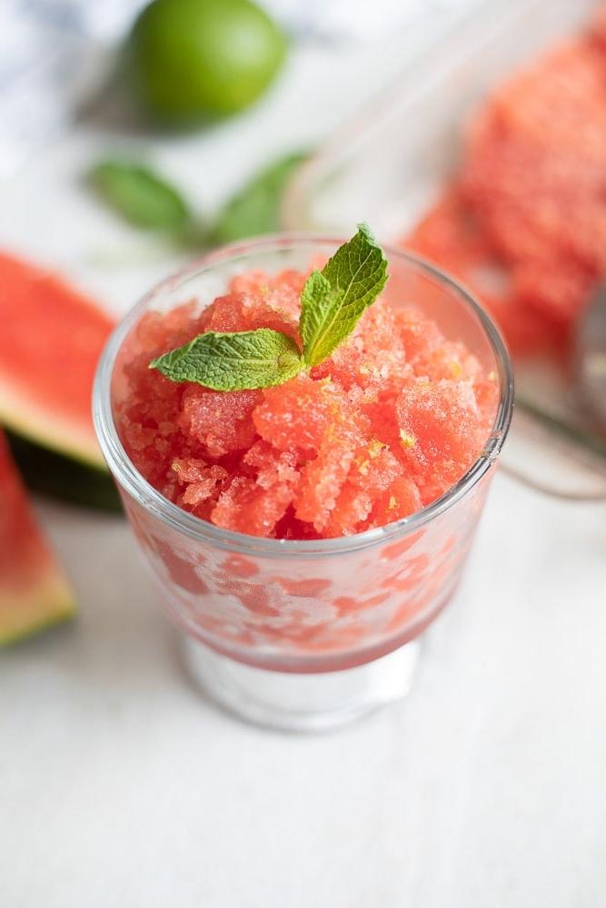 Wassermelonen Granita Wassermelonen Granita in einer Glasschale mit Minzblättern und Minz-Zucker.