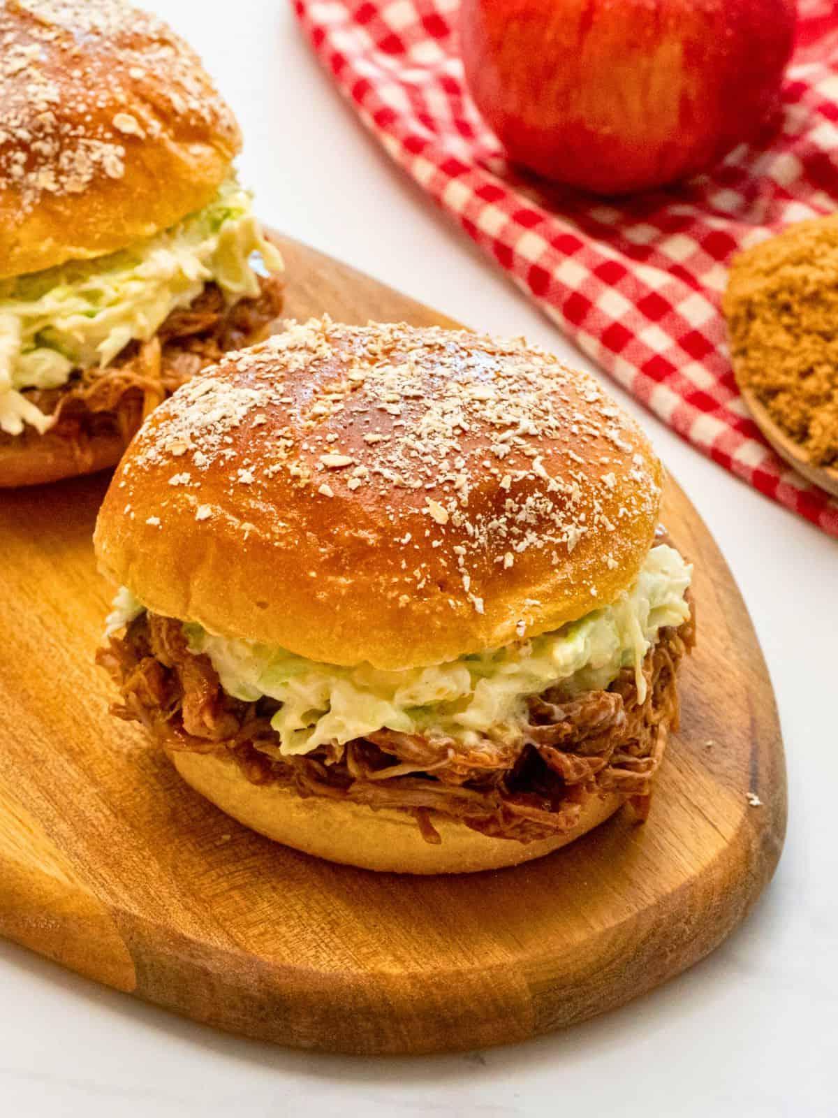 Instant Pot Pulled Pork in Brötchen serviert, garniert mit hausgemachtem cremigem Krautsalat.