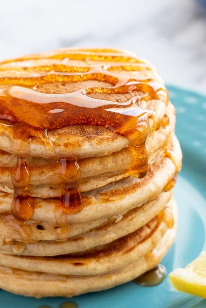 Stapel Vollkornpfannkuchen mit Ahornsirup beträufelt.