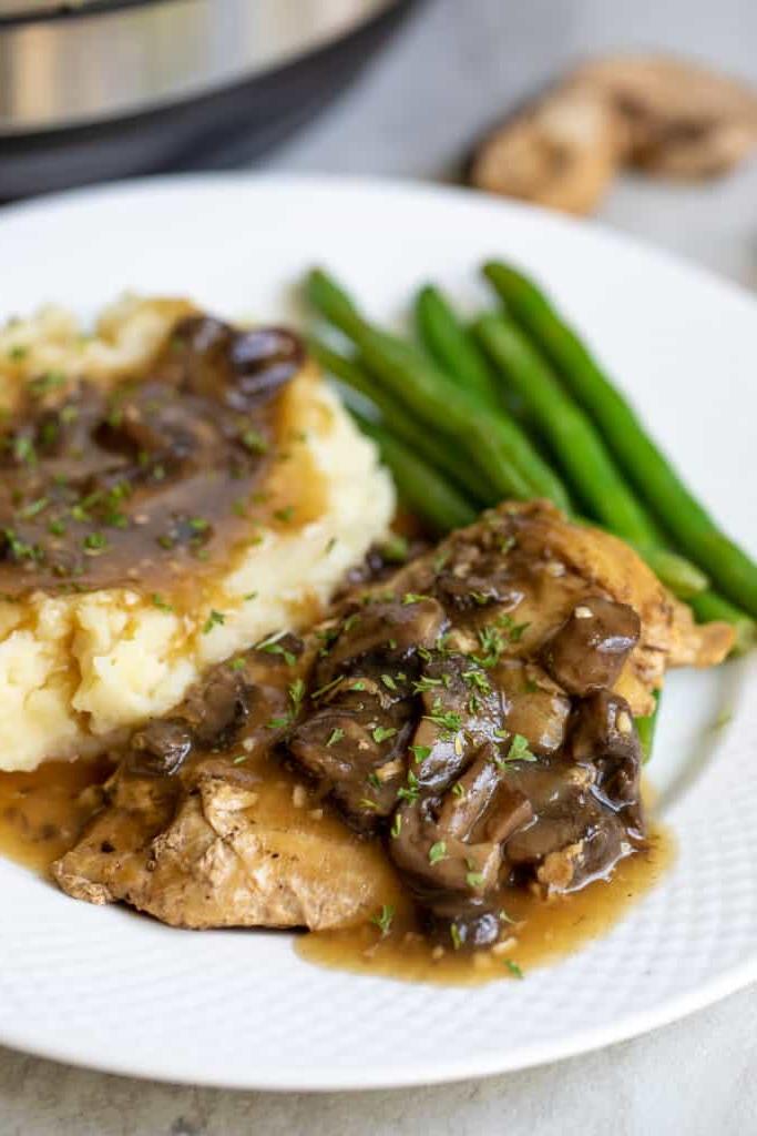 Instant Pot Hähnchen Marsala auf weißem Teller mit Kartoffelpüree und grünen Bohnen