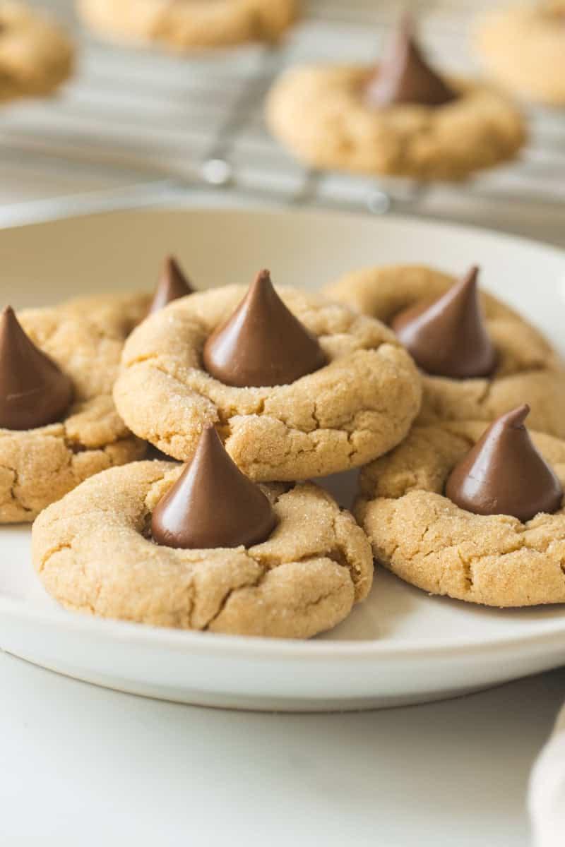 Weiße Platte mit Erdnussbutter-Keksen, die mit einem Hershey's Schokokuss belegt sind.