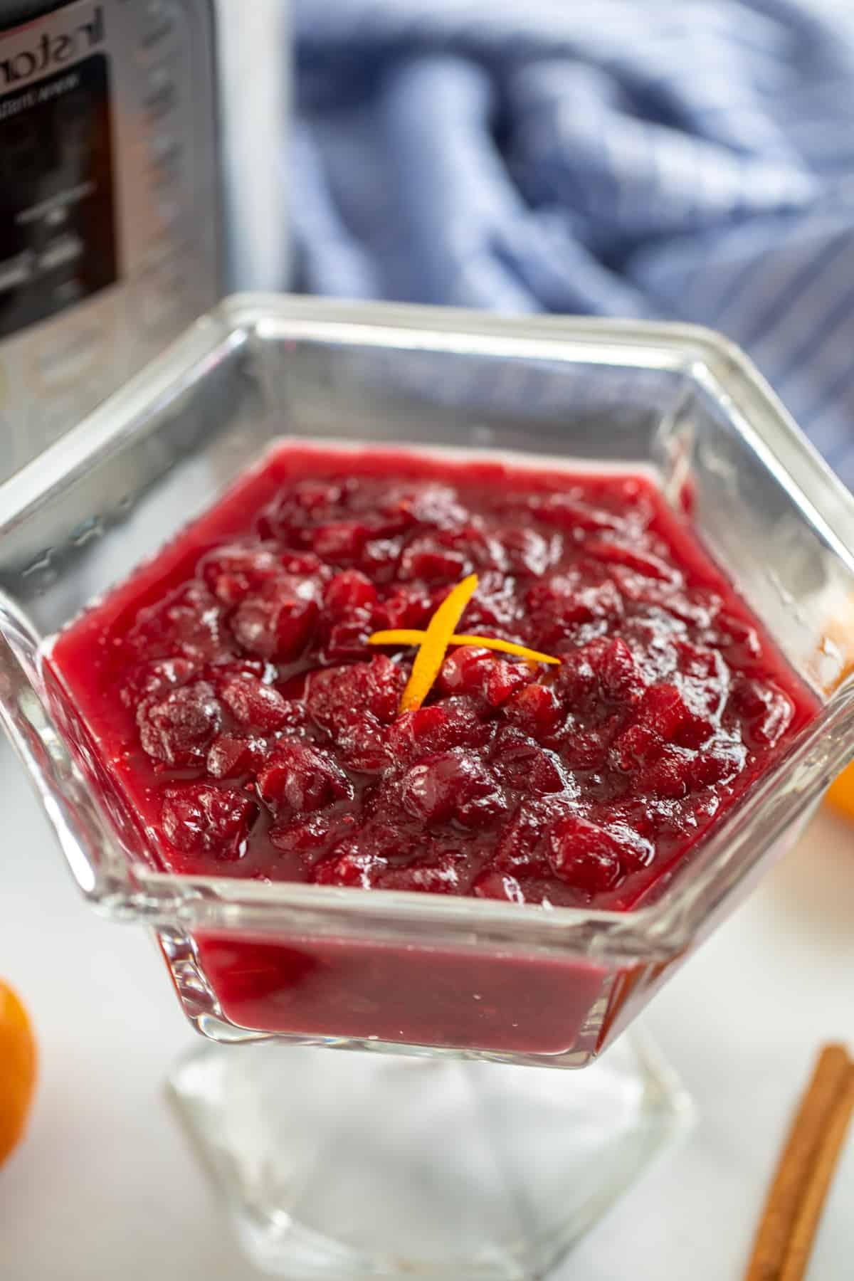 Instant Pot Preiselbeersauce in einer durchsichtigen Glasschale neben dem Instant Pot.