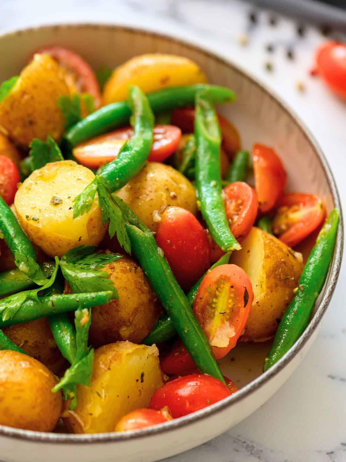 Rezept Italienischer Kartoffelsalat Schüssel mit italienischem Kartoffelsalat, garniert mit frischer Petersilie.