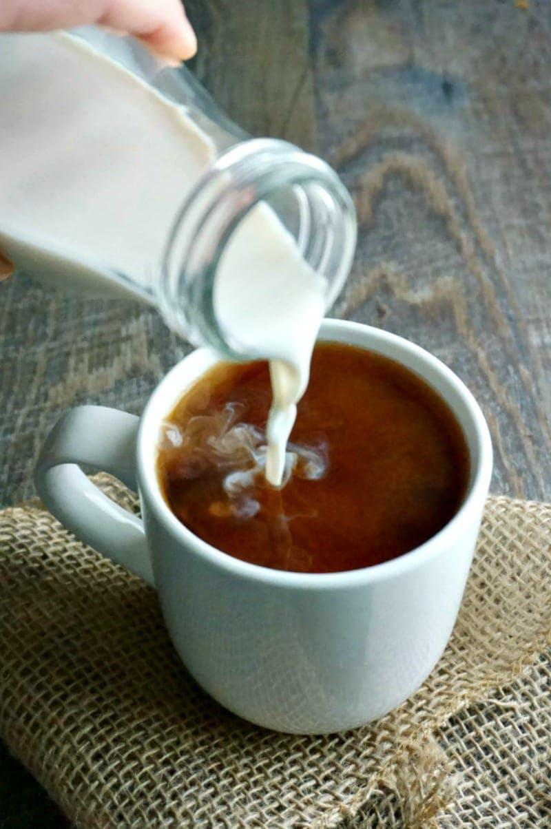 Kokos-Vanille-Kaffeeweißer wird in eine Kaffeetasse gegossen.