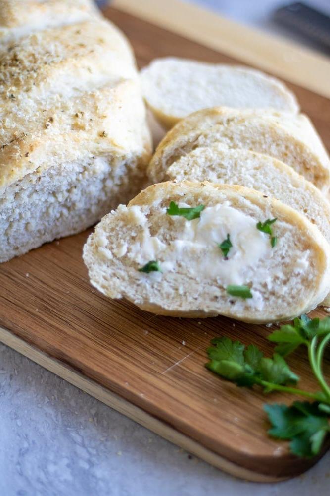 Italienisches Brot Geschnittenes italienisches Brot mit Butter auf einem Schneidebrett.
