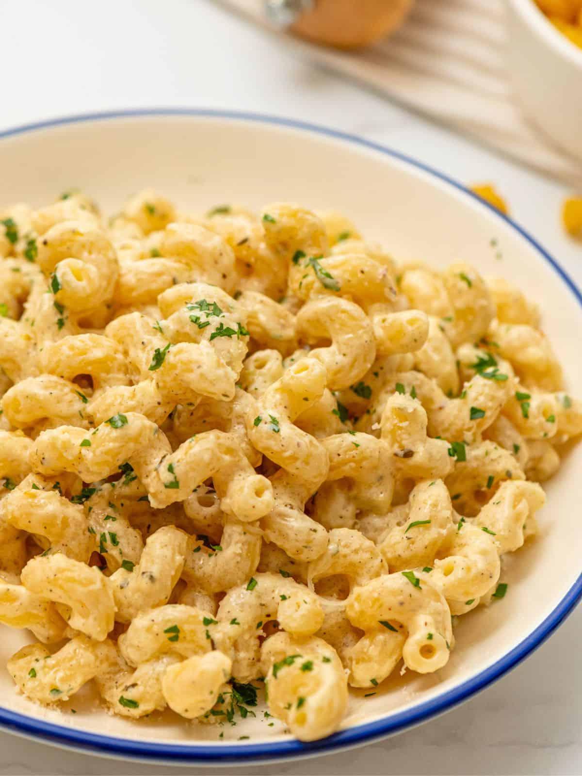 Cremige Cavatappi Pasta in einer Schüssel, bestreut mit frischer Petersilie. Einladendes Bild eines fertigen Nudelgerichts.