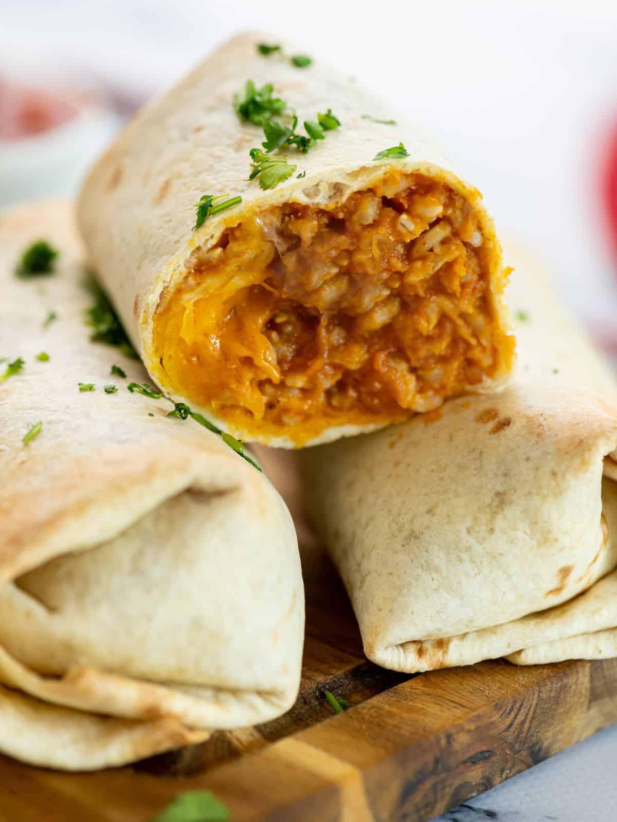 Bohnen-Burrito aufgeschnitten, um die Füllung aus Reis, Käse und Bohnenmus zu zeigen.