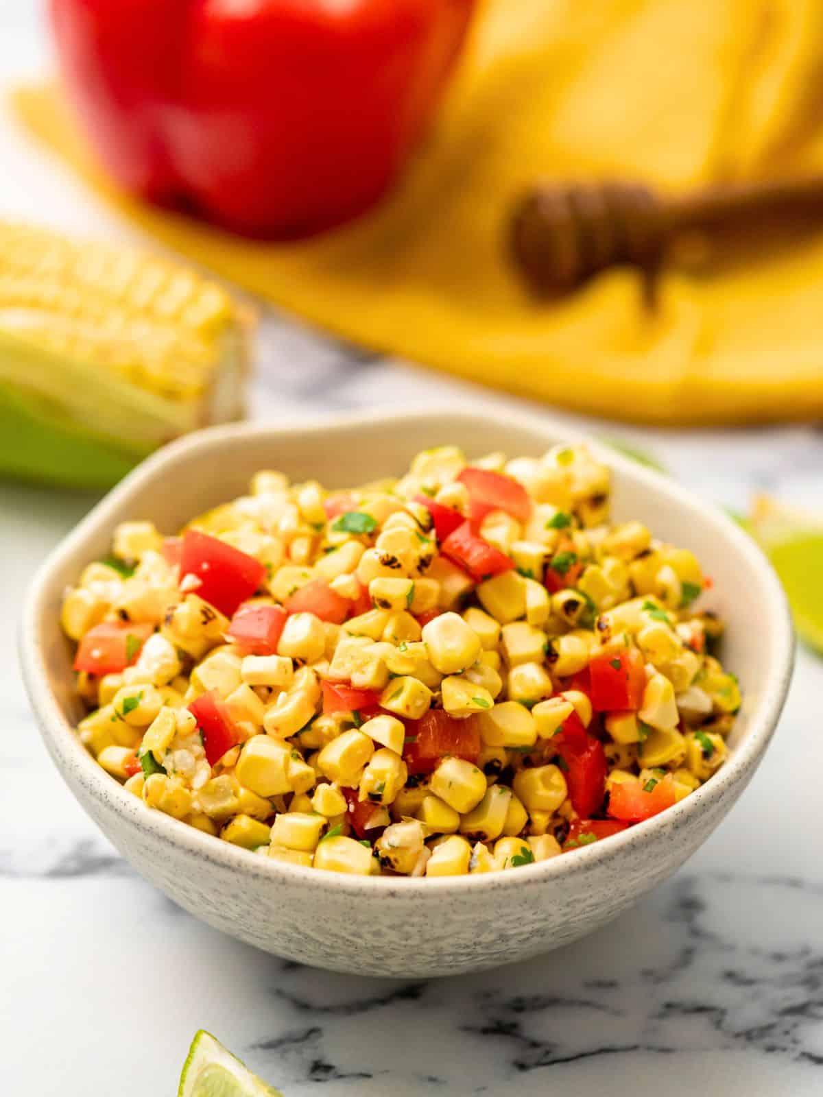 Schale mit gegrillter Maissalsa mit roter Paprika und Honig-Limettendressing.