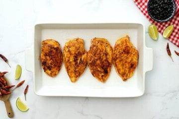 Angebratene Hähnchenbrustfilets mit Cowboy-Aroma in einer weißen Auflaufform.