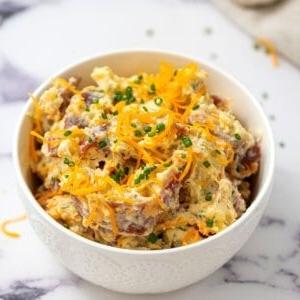 Schüssel mit Bacon Ranch Kartoffelsalat, garniert mit Schnittlauch.