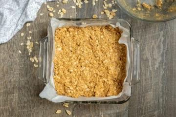 Erdnussbutter-Haferflocken-Riegel in einer mit Backpapier ausgelegten Backform.