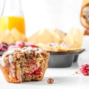 Cranberry-Orangen-Muffin mit abgebissenem Stück, das die Schichten des Kaffeekuchen-Muffins zeigt.
