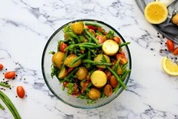 Zutaten für italienischen Kartoffelsalat in einer großen Rührschüssel vermischt.