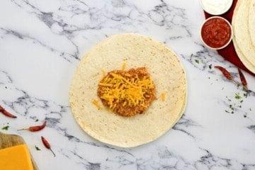 Bohnenmus und Käse auf einer Weizen-Tortilla.