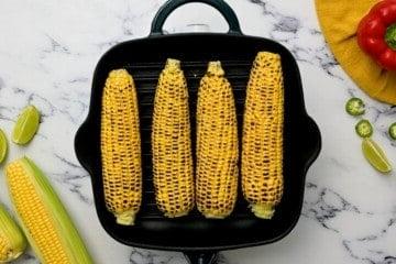 Frischer Maiskolben auf einer Grillplatte.