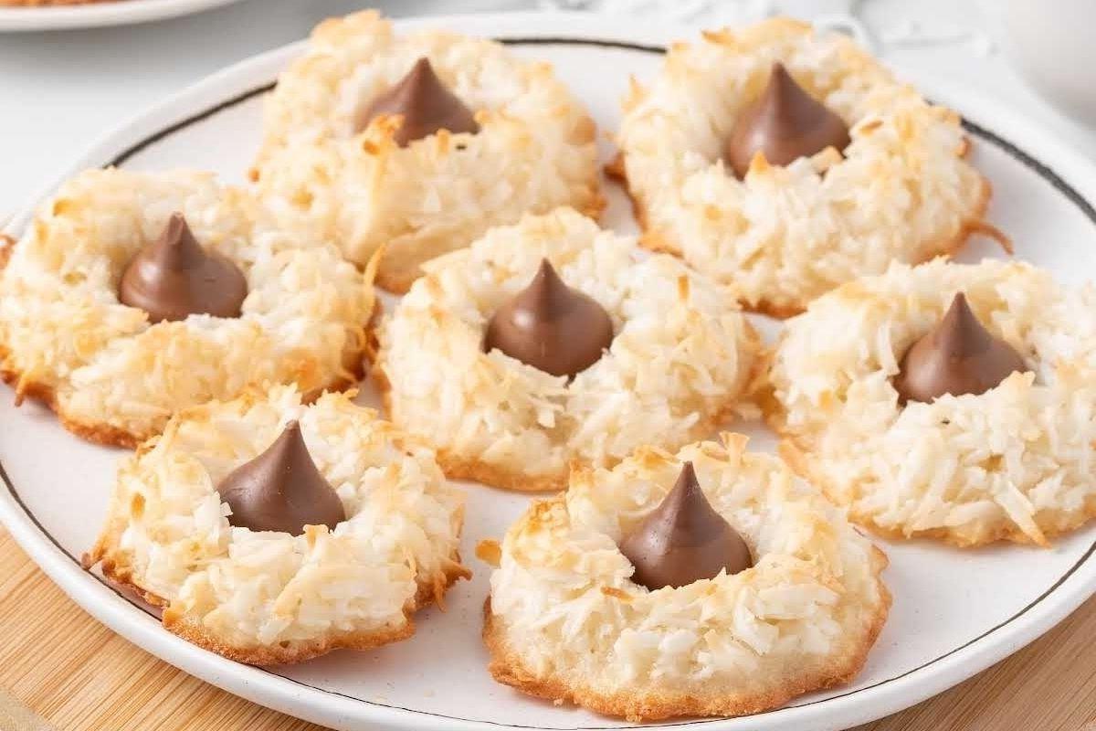 9 Erdnussbutter-Keksteigkugeln auf einem Backblech, nachdem sie in Kristallzucker gewälzt wurden.