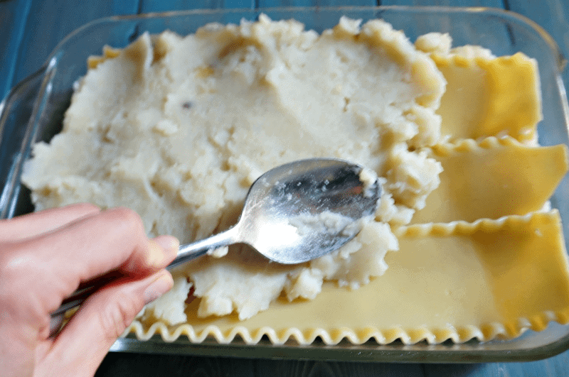 Schichtung von Kartoffelpüree auf Lasagneplatten.
