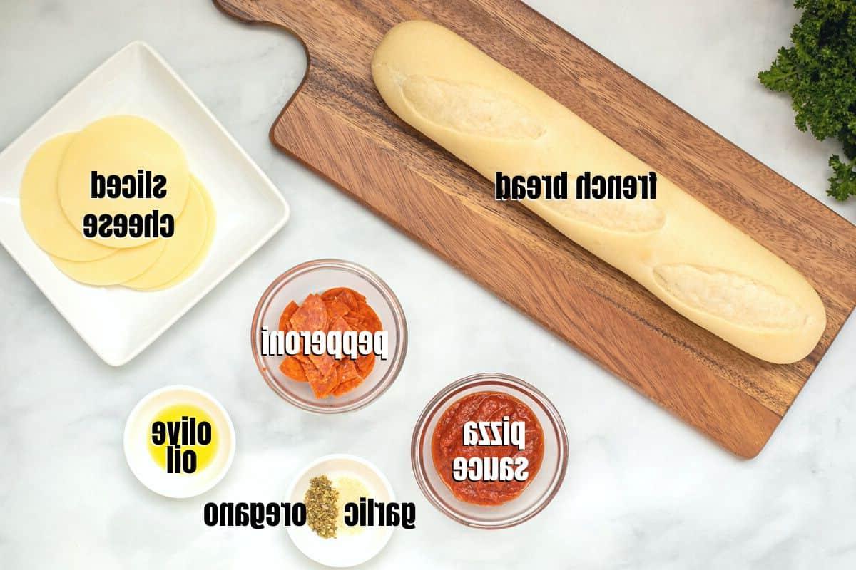 Heißluftfritteusen Baguette Pizza Rezept Zutaten für Heißluftfritteusen Baguette Pizza, beschriftet auf der Arbeitsplatte.