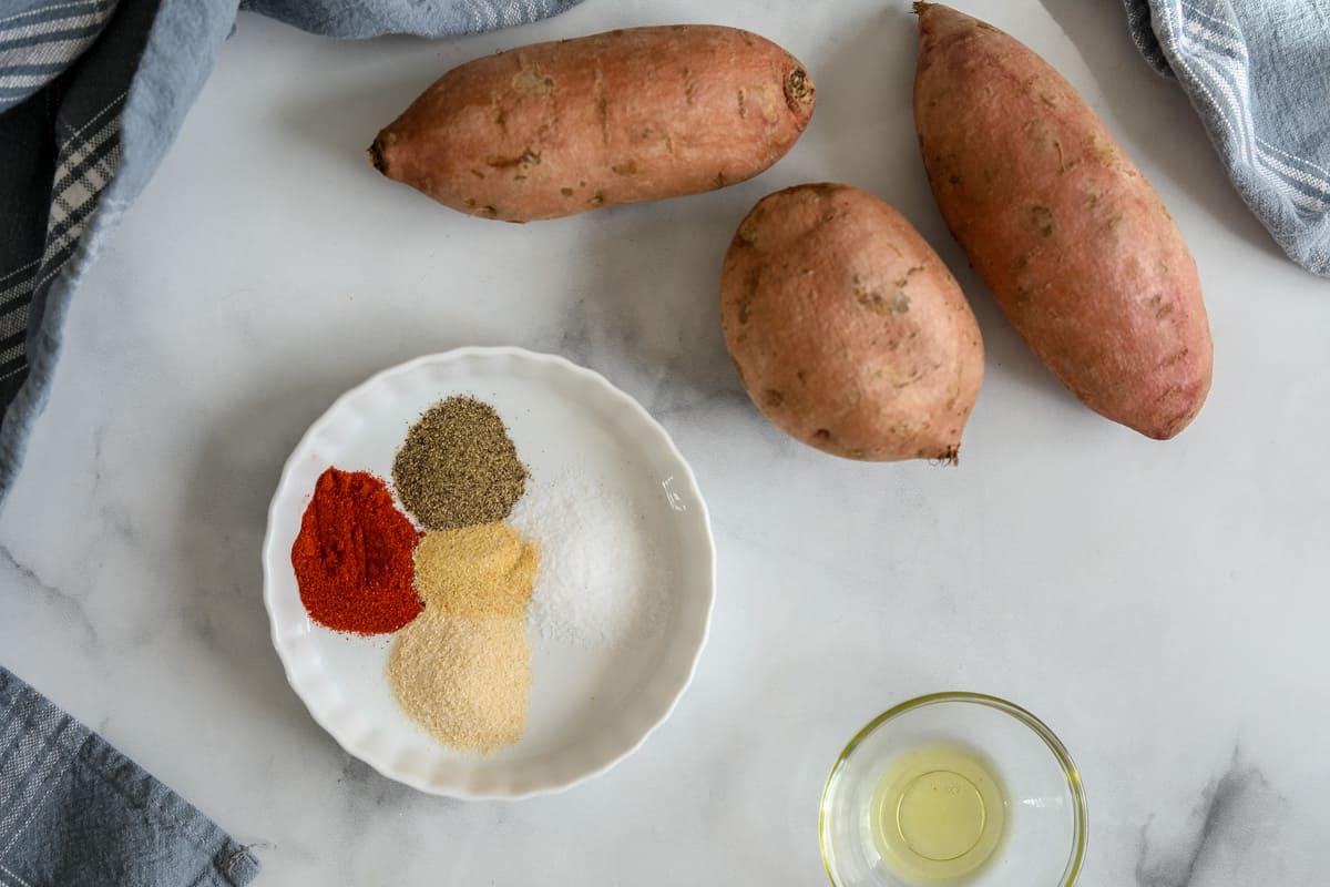 Süßkartoffeln Heißluftfritteuse Zutaten für Süßkartoffeln aus der Heißluftfritteuse auf der Arbeitsplatte.