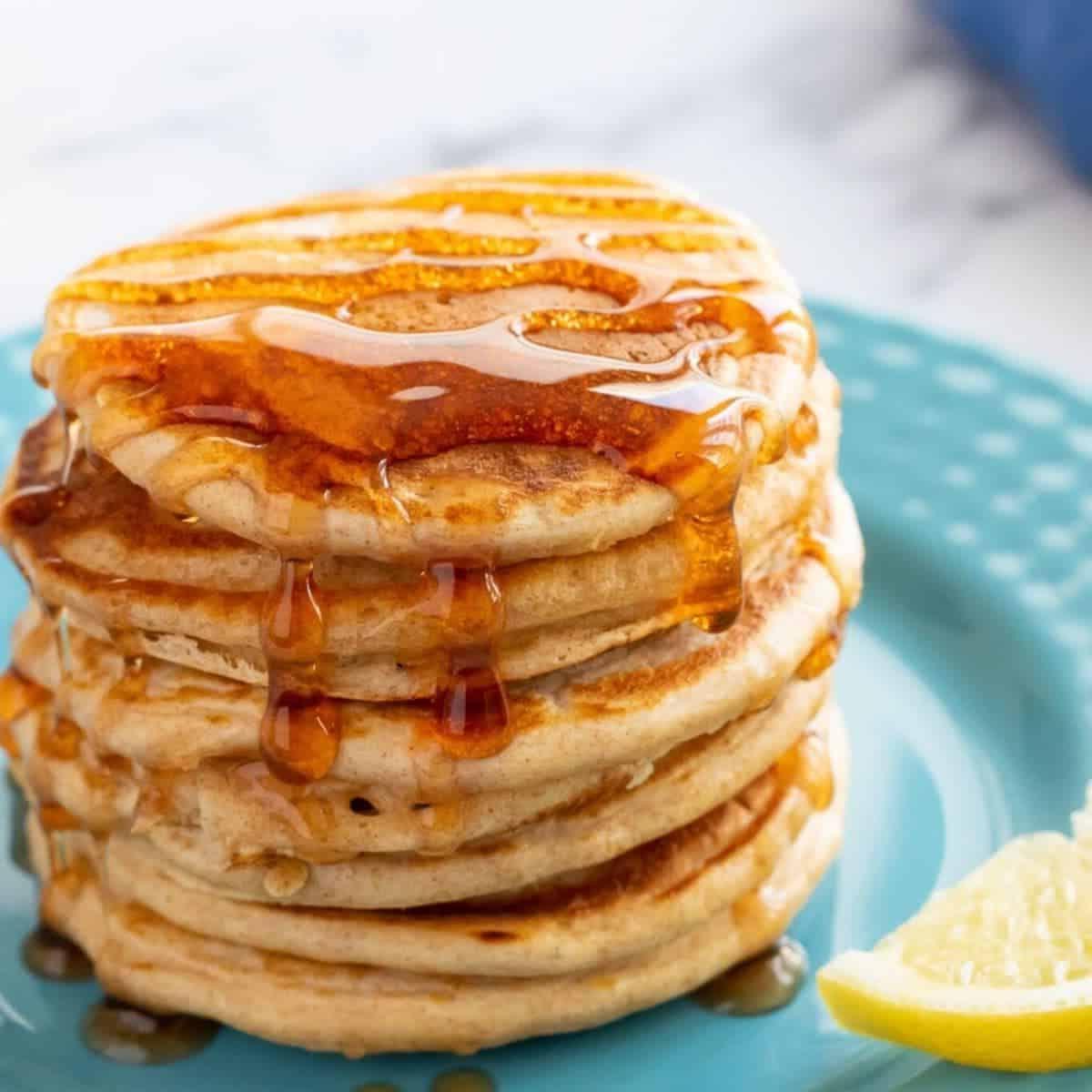 Stapel Pfannkuchen mit Sirup auf blauem Teller