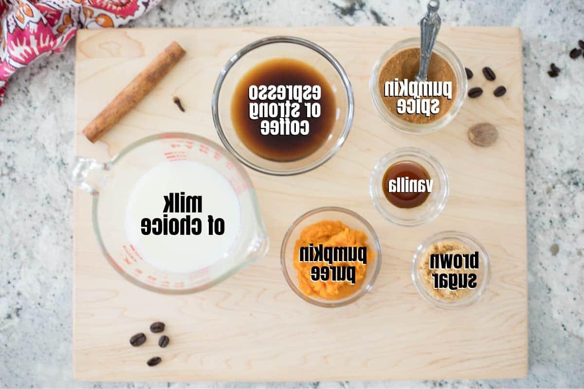 Zutaten für Kürbisgewürz Latte beschriftet auf einem Holzschneidebrett.
