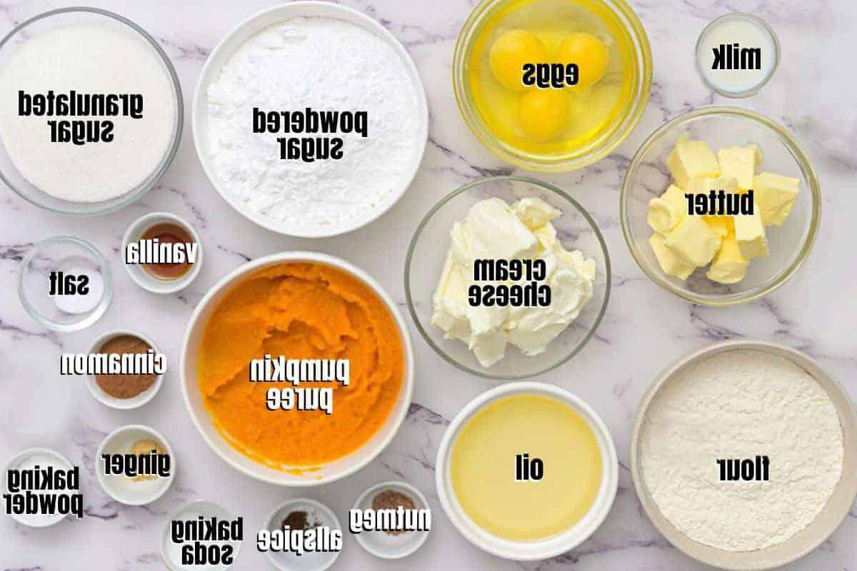 Rezept für Kürbisgewürzkuchen Zutaten für Kürbisgewürzkuchen und Frischkäse-Frosting, auf der Arbeitsplatte beschriftet.