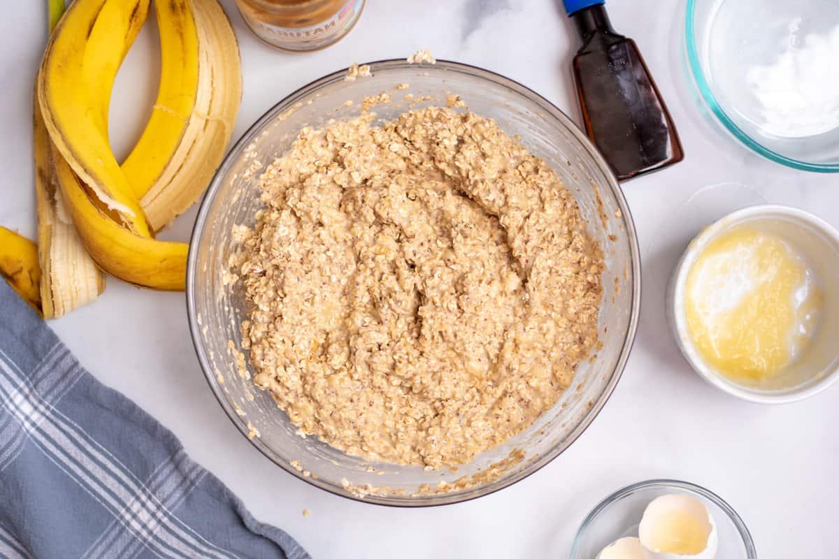 Zubereitung des Haferflocken-Muffin-Teigs Haferflocken-Muffin-Teig neben Bananenschalen in einer durchsichtigen Rührschüssel.