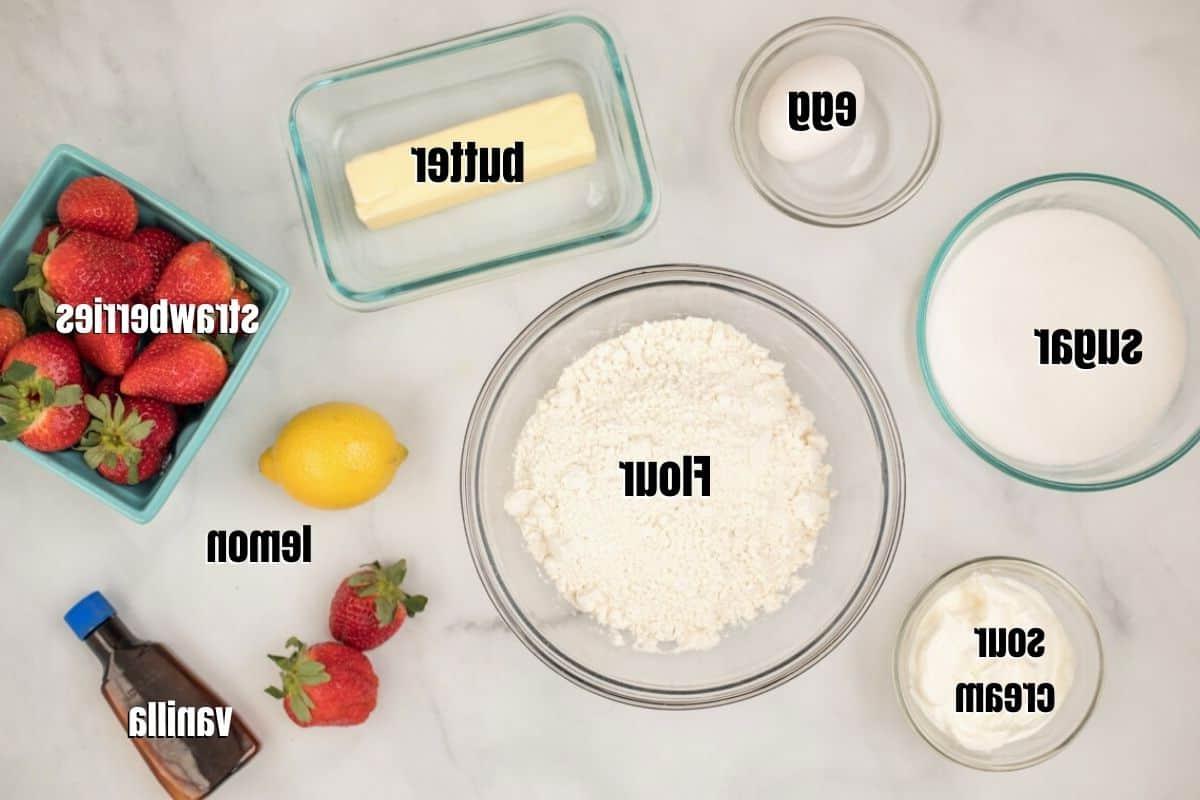 Erdbeer-Krümel-Schnitten Zutaten für Erdbeer-Streusel-Schnitten auf der Theke angeordnet.