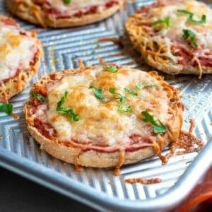Gebackene English Muffin Pizza mit Käse auf einem Backblech.