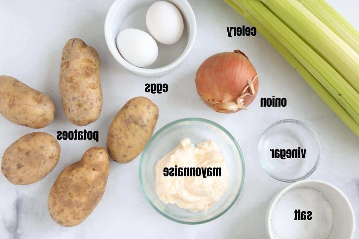 Zutaten für Kartoffelsalat auf einer Küchenzeile, beschriftet.