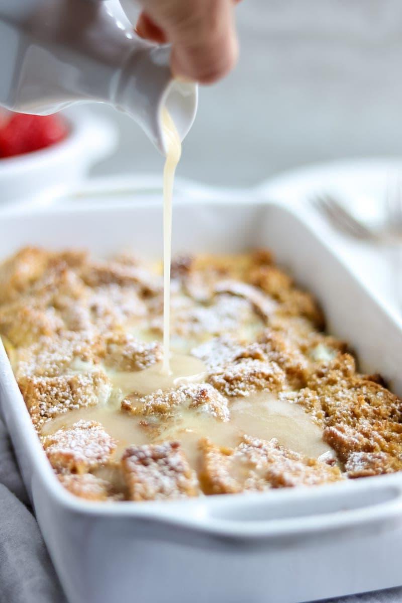 Bourbon-Glasur wird über Overnight Eierlikör French Toast Auflauf gegossen.