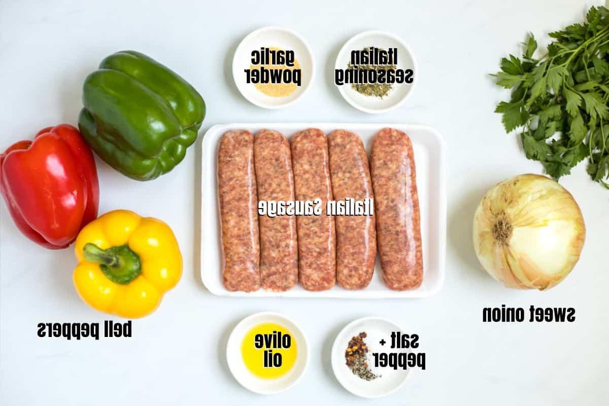 Zutaten für gebackene Wurst mit Paprika und Zwiebeln, beschriftet auf der Arbeitsplatte.