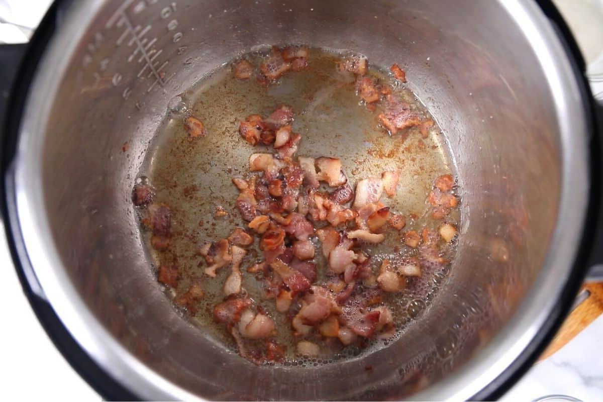 Instant Pot Blattkohl mit Speck Angebratener Speck im Innentopf des Instant Pots.