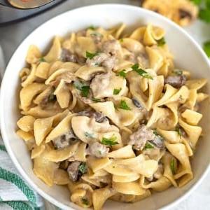 Instant Pot Rinder-Stroganoff 2 Instant Pot Rindfleisch Stroganoff in weißer Schüssel mit hausgemachter Pilzsoße und Eiernudeln.