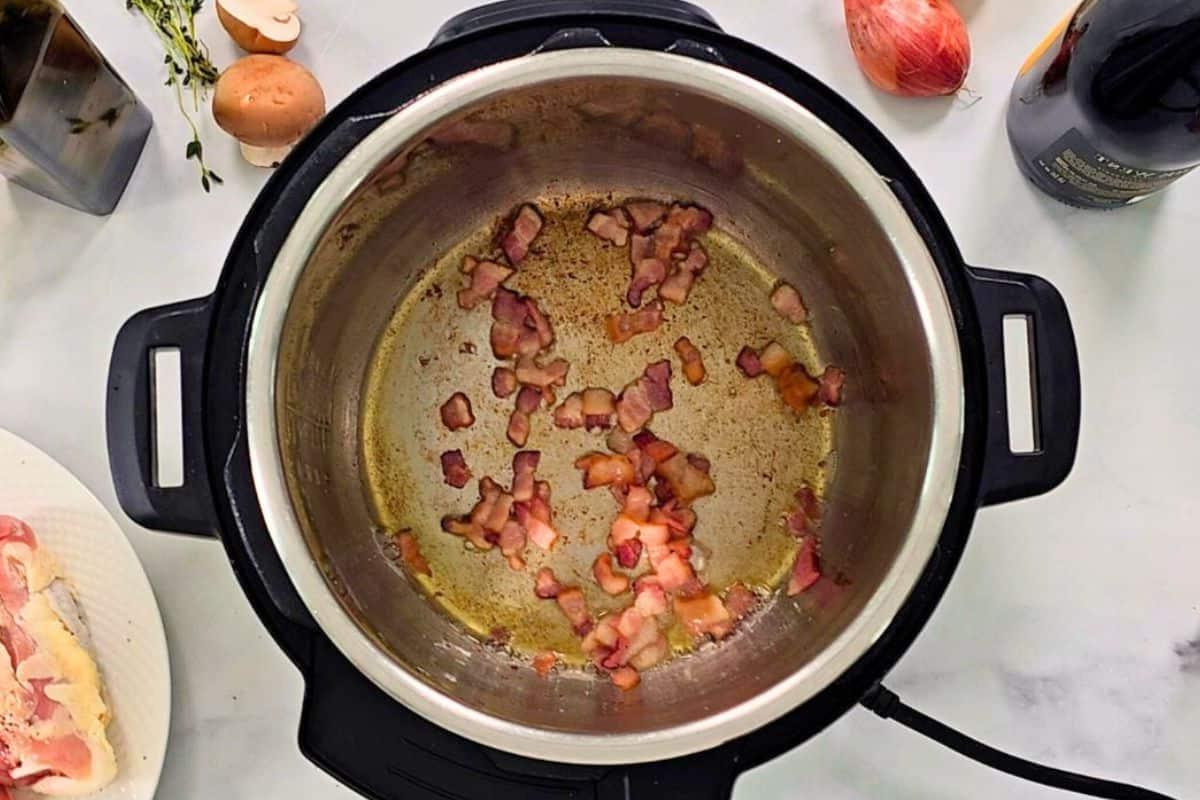 Gewürfelten Speck im Instant Pot für Coq au Vin anbraten.