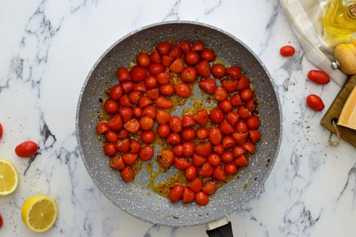 Halbierte Datteltomaten in der Pfanne mit Gewürzen angebraten.