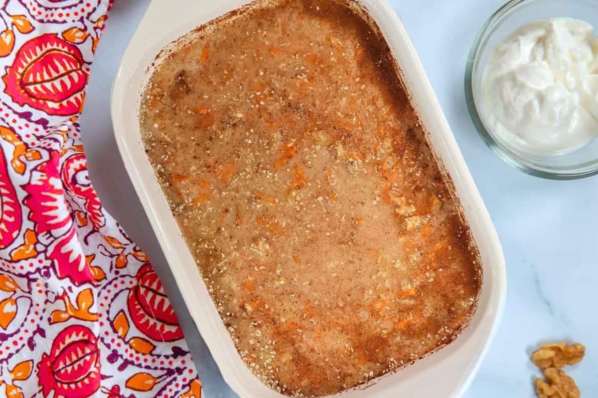 Zutaten für Karottenkuchen-Haferflocken-Auflauf in einer 2-Liter-Auflaufform mit Walnüssen daneben.