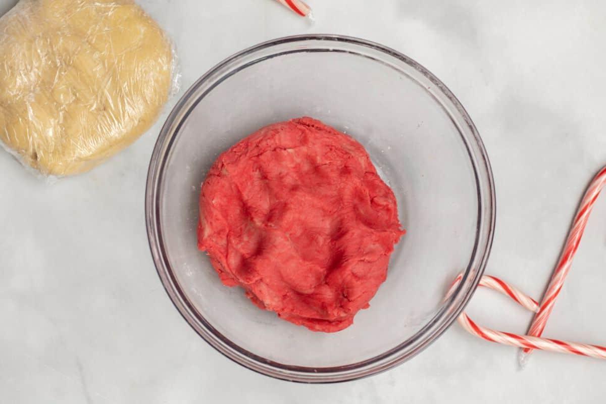 Plätzchenteig für Zuckerstangen-Plätzchen in der Schüssel, nachdem er rot gefärbt wurde.