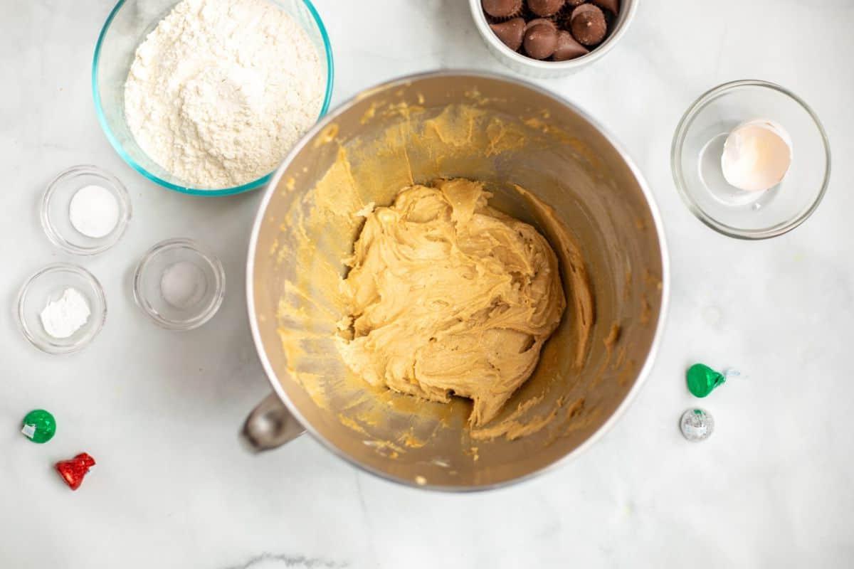 Teig für Erdnussbutter-Kekse in einer Rührschüssel neben trockenen Zutaten.