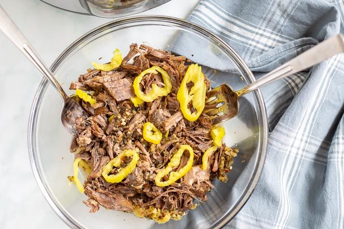 Schüssel mit geschreddertem Italienischem Rindfleisch, belegt mit Pepperoncini-Paprika.
