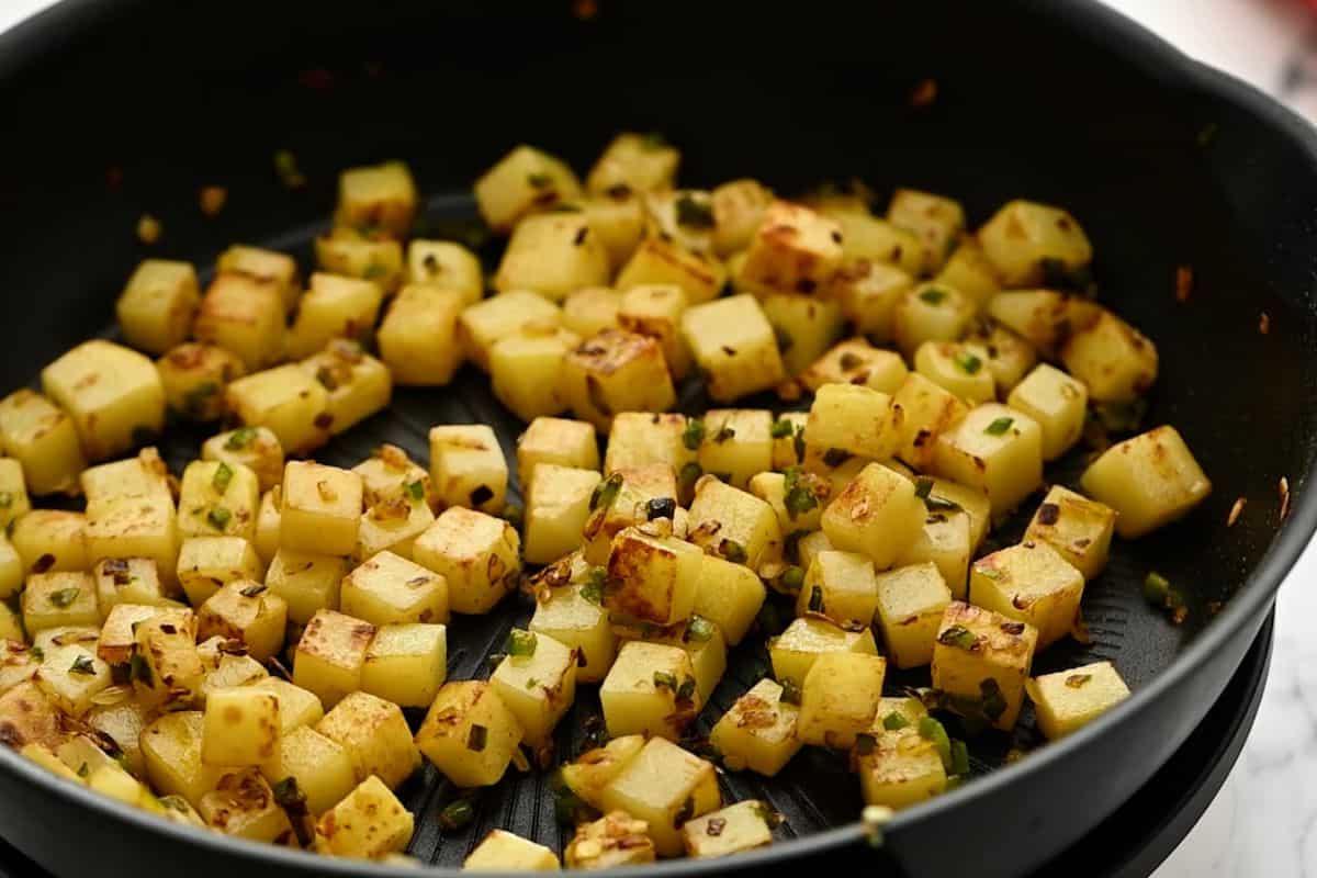 Knusprige Kartoffelwürfel in der Pfanne.