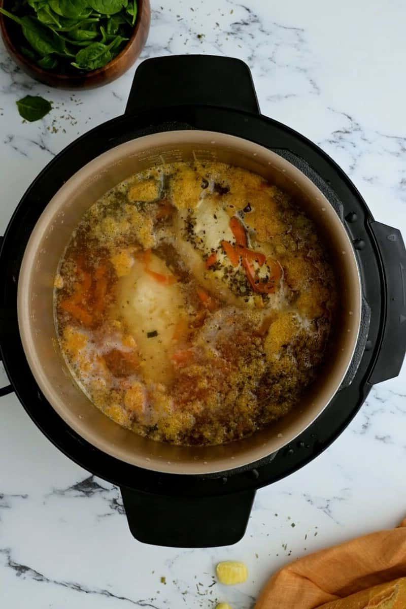 Innerer Topf mit pochiertem Hähnchen in Brühe für die Gnocchi Suppe nach dem Druckkochen.