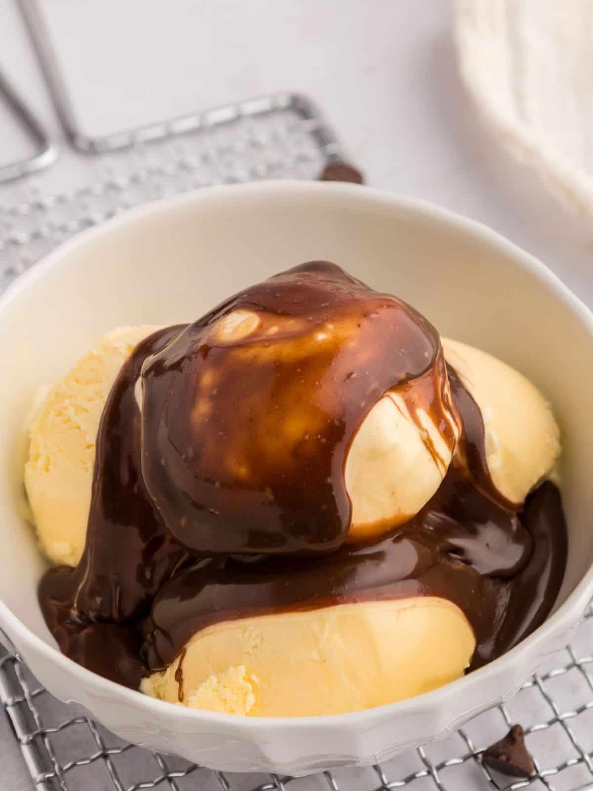 Schüssel mit Vanilleeis, beträufelt mit Hot Fudge Soße.