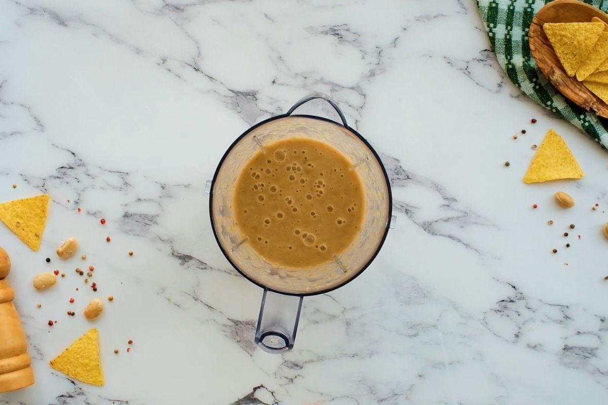 Pürierte Bohnen und Brühe im Mixer für cremiges weißes Hähnchen-Chili.