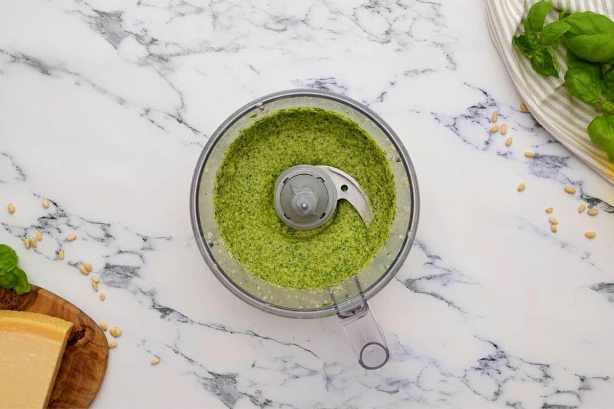 Hausgemachtes Basilikumpesto in einem Food Processor, bereit zum Verarbeiten.