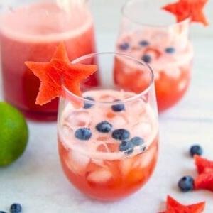 Wassermelonen-Sangria im Glas mit Wassermelonensternen, garniert mit Heidelbeeren.