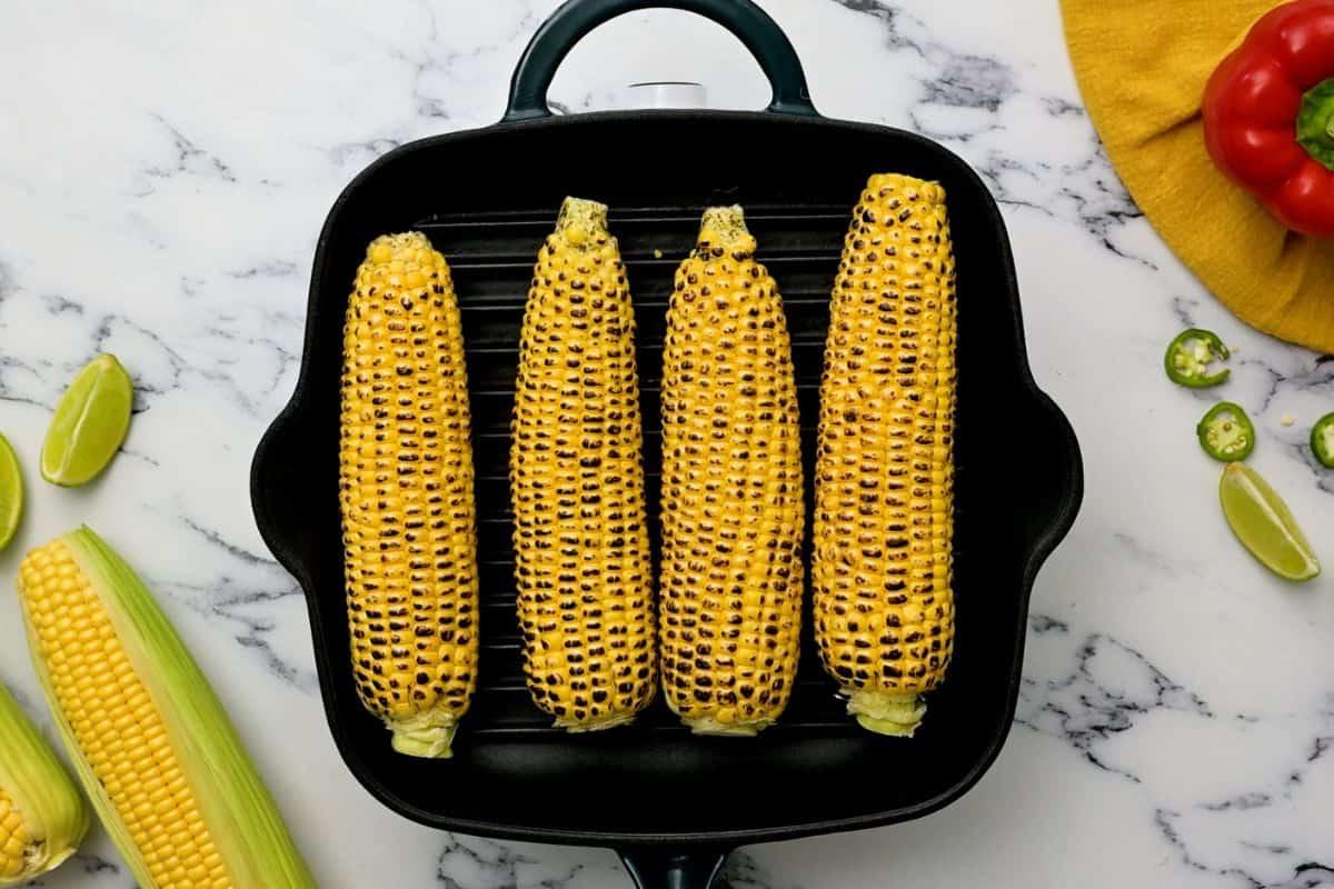 Frischer Maiskolben auf einer Grillplatte.