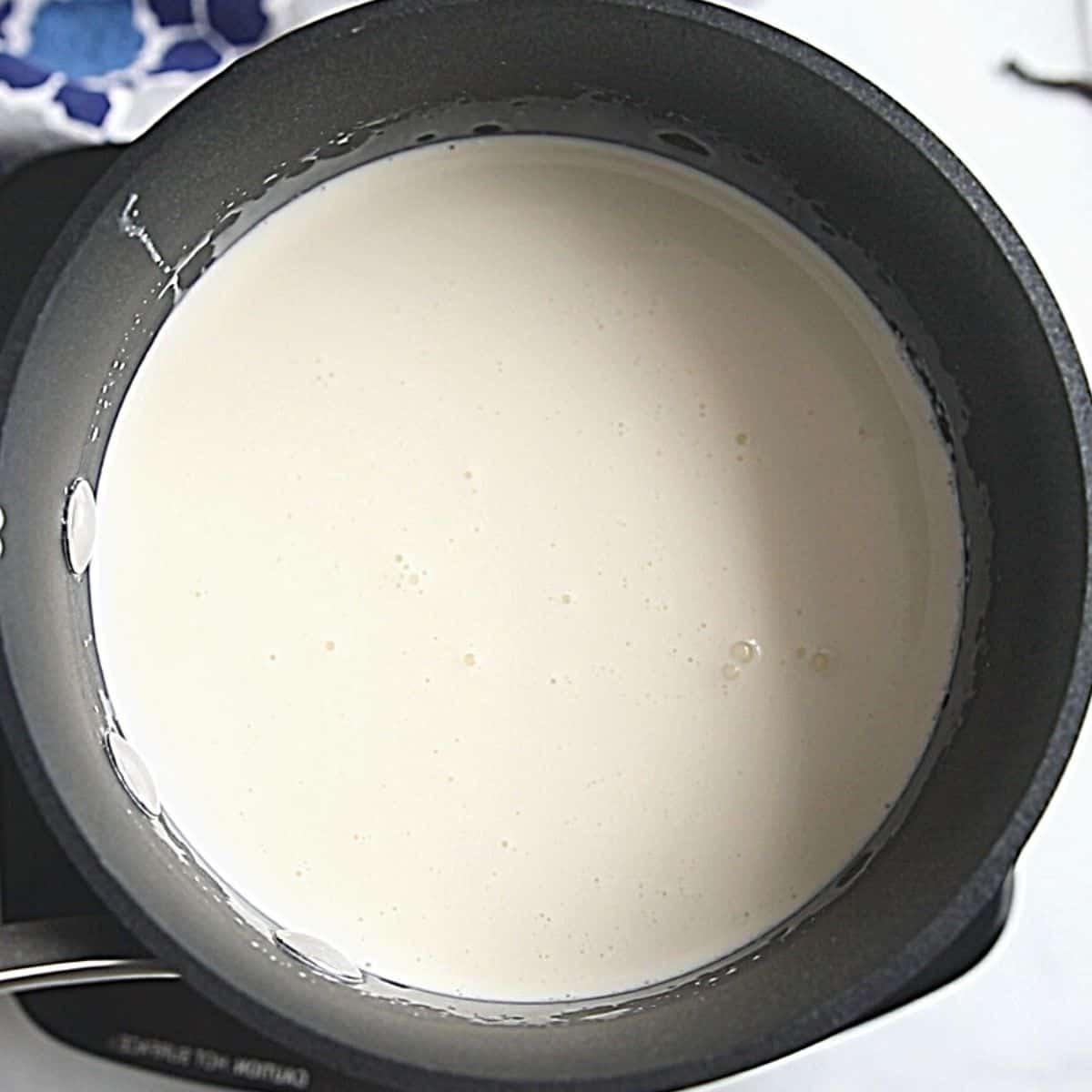 Rezept für hausgemachtes Vanilleeis – Basis Sahne-Milch-Zucker-Mischung im Topf, sanft erwärmt für die hausgemachte Eisbasis.