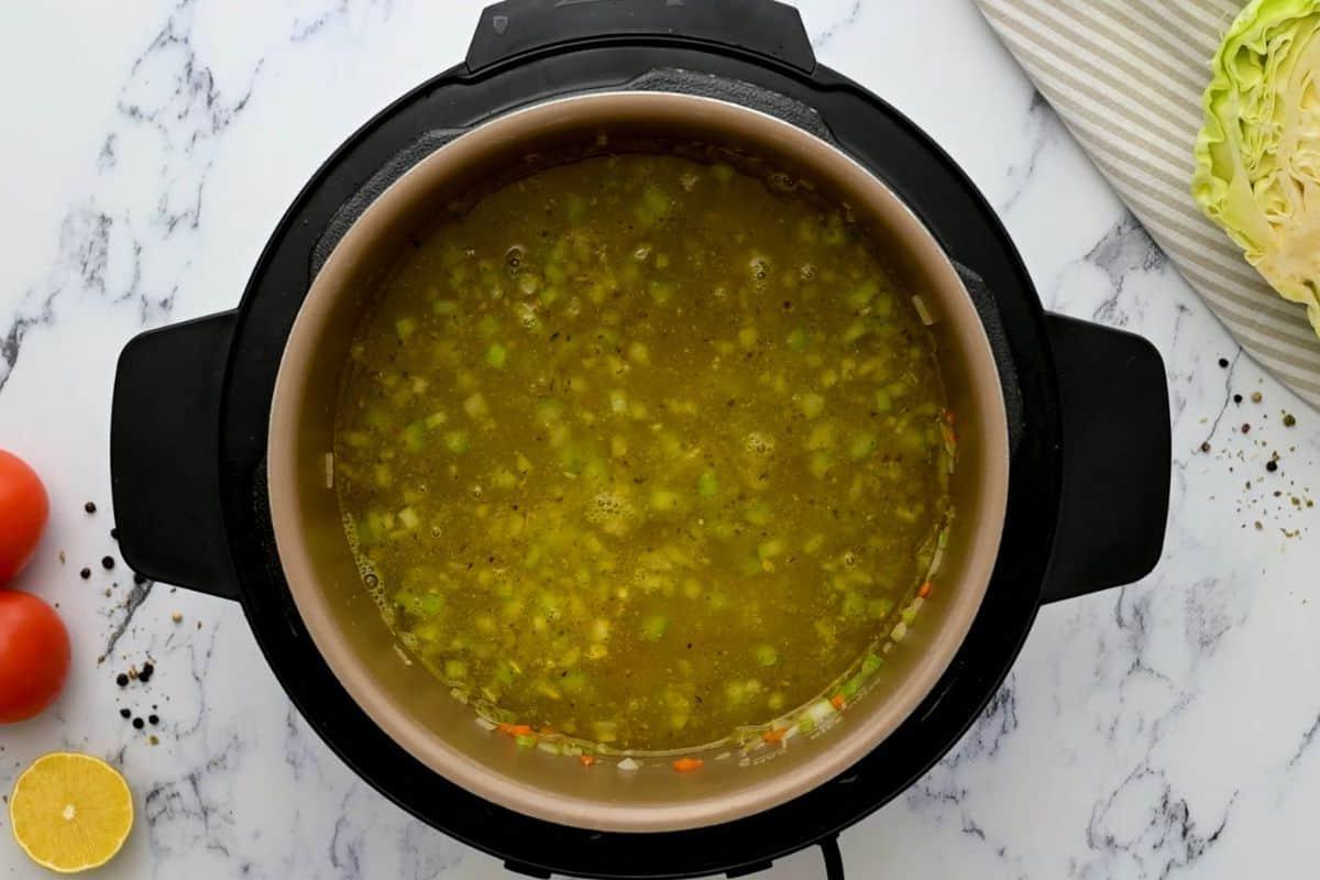 Kohlsuppe Instant Pot Deglasieren Brühe wird nach dem Anbraten des Gemüses in den Innentopf gegossen.