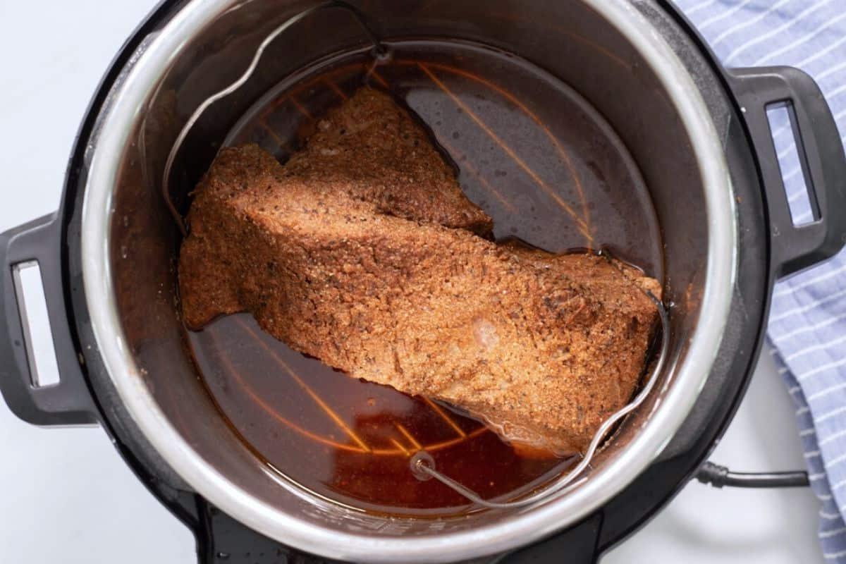 Druckgegartes Brisket im Innentopf auf Metalluntersetzer.